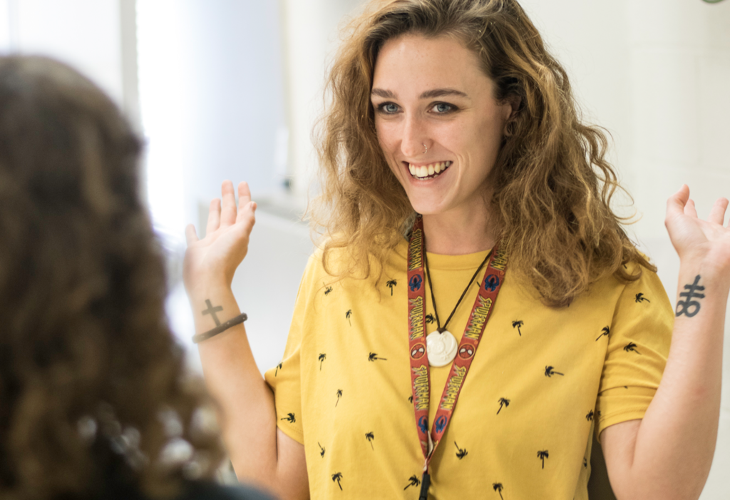 Student happily raises her arms in conversations during class