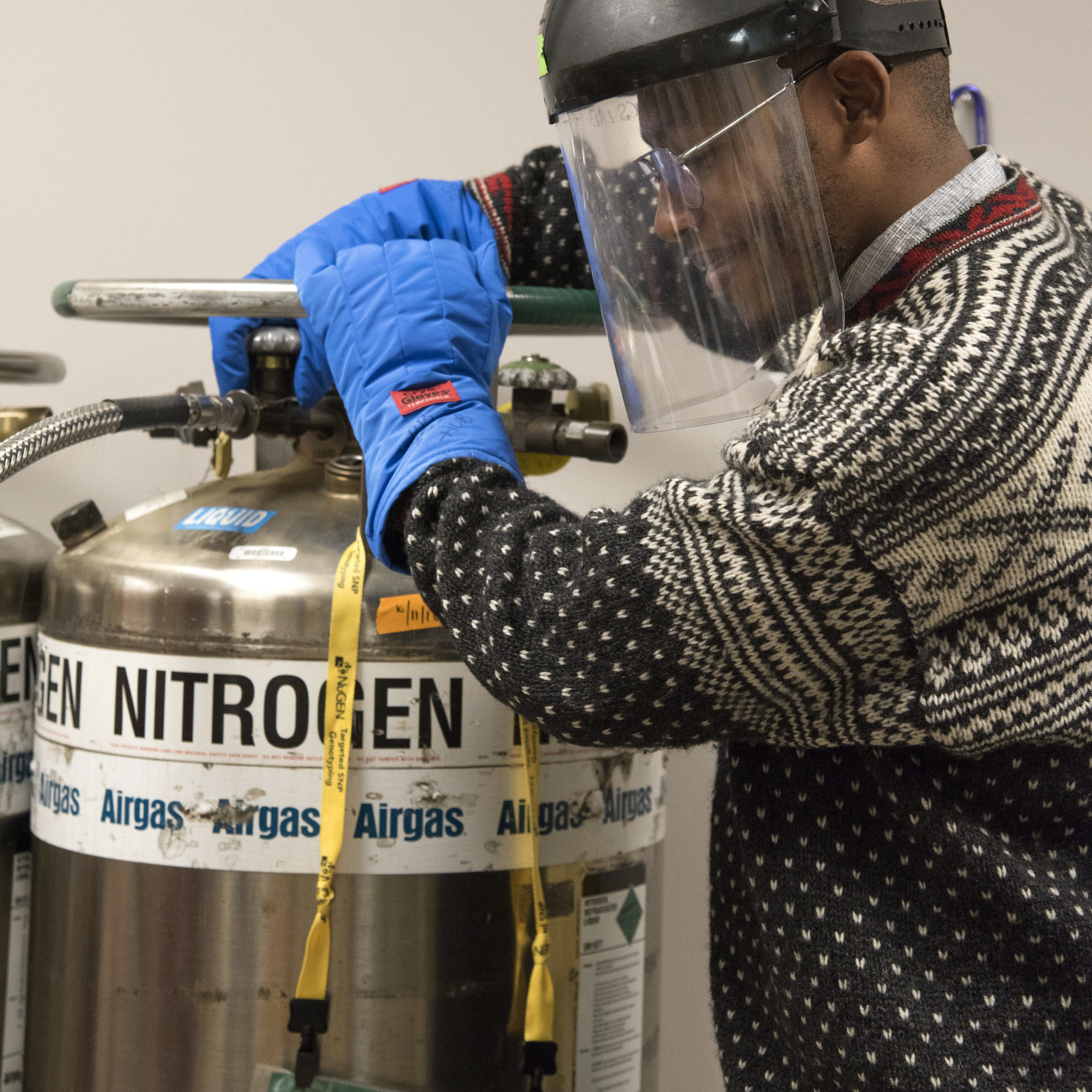 Student adjusts Nitrogen tank in face shield and gloves 