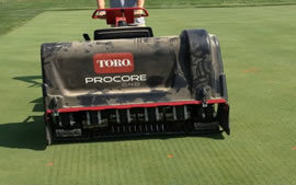 Large professional turf aerifier being pushed over a golf green

