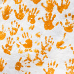 Orange handprints on a white rock