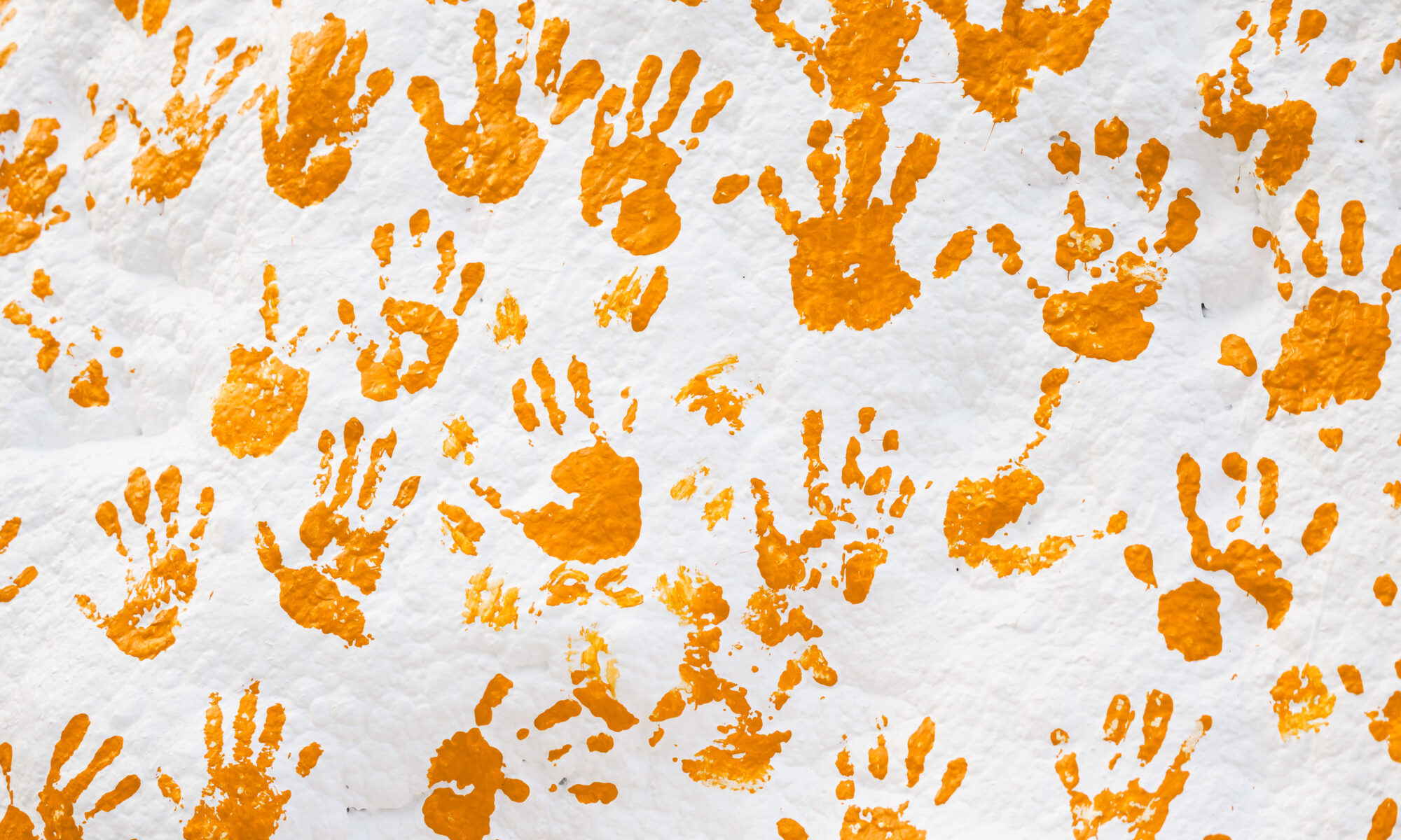 Orange handprints on a white rock