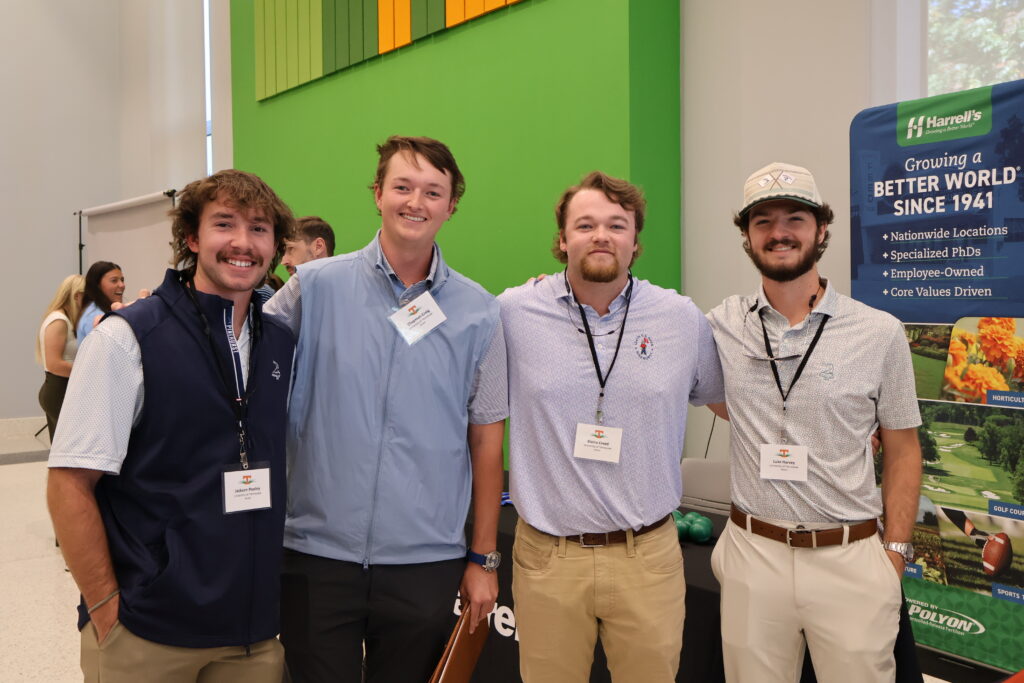 Four men smiling looking at the camera