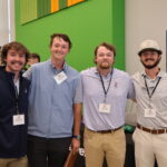 Four men smiling looking at the camera