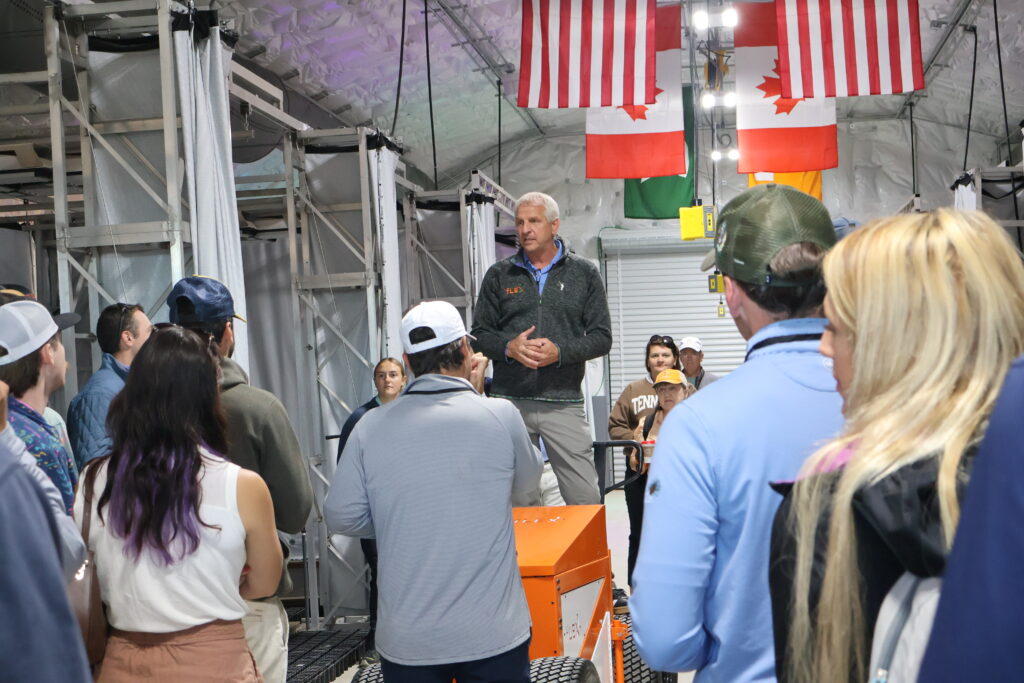 Man standing on an elevated platform talking to a group
