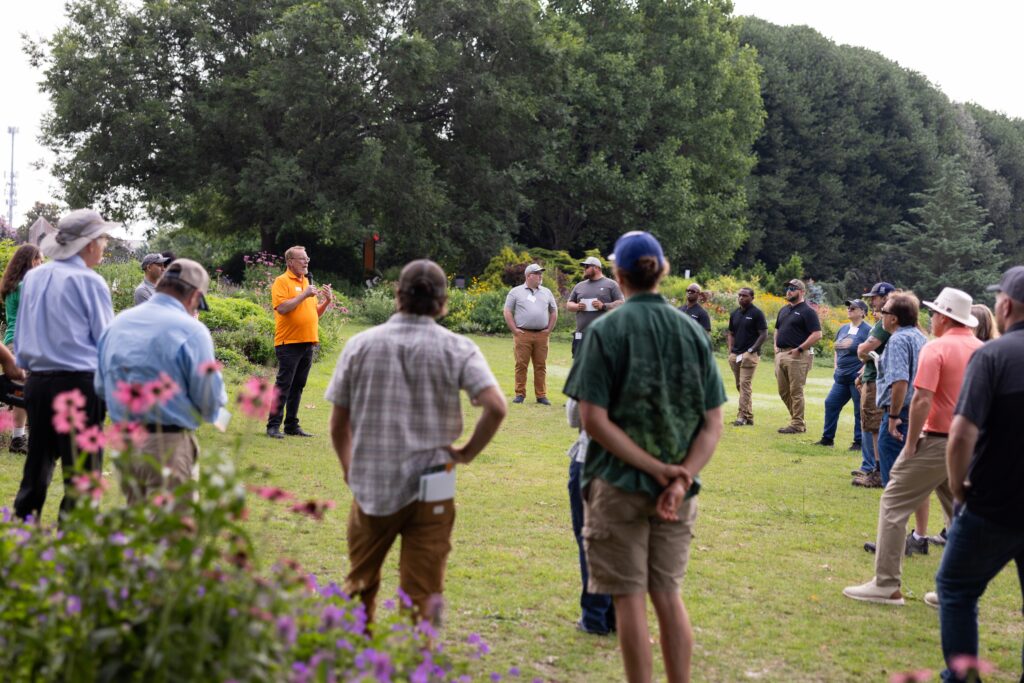 Man speaking to a group of people at the UT Gardens