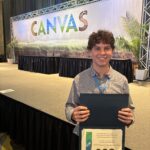 Photo of a man holding up an award