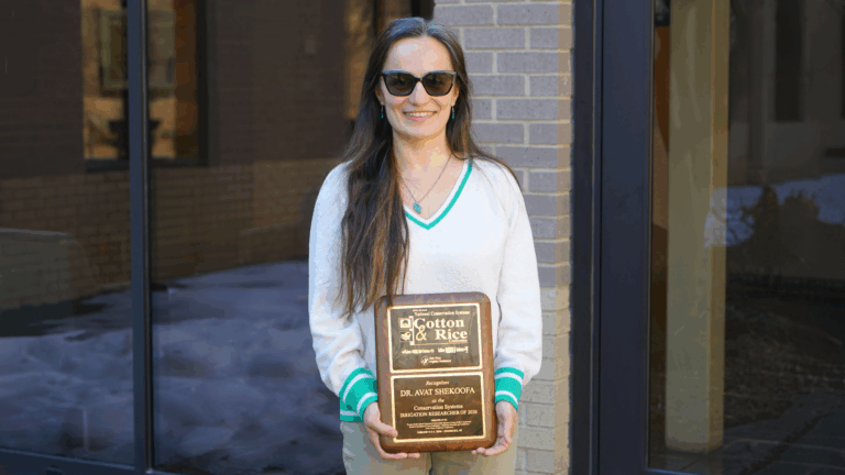 Woman with sunglasses posing with a plaque