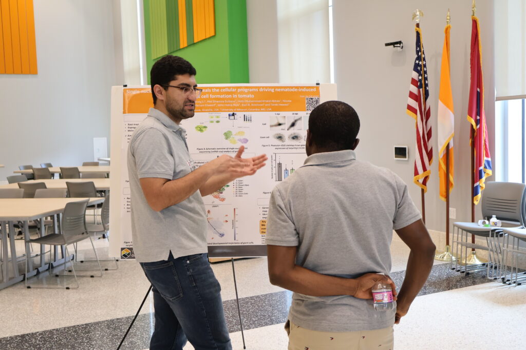 Man watching another man present a poster