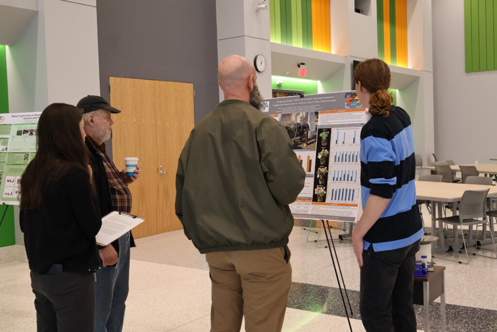 People watching someone present a poster