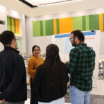 People gathered around a poster and presenter