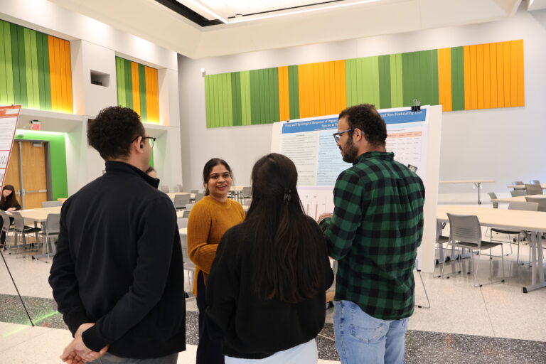 People gathered around a poster and presenter
