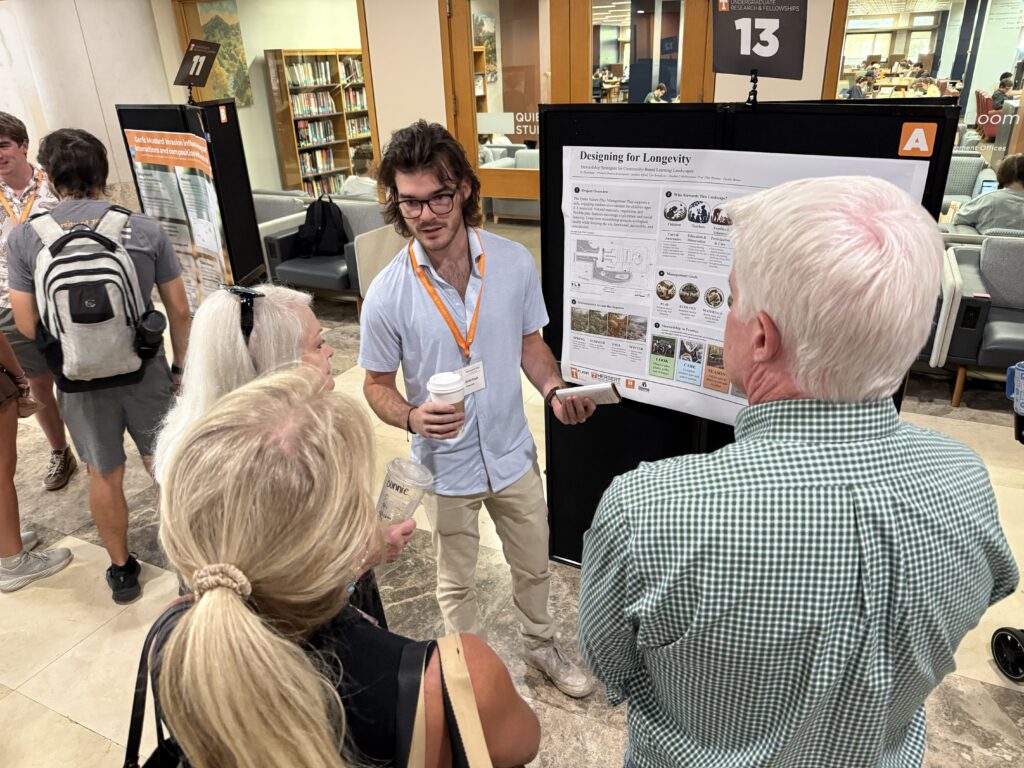 Man presenting a poster in front of a group of people