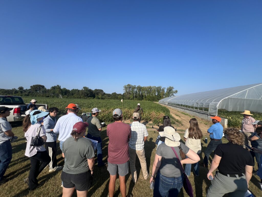 Group of people listening to a speaker at a farm